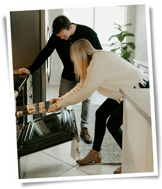 A couple enjoying fresh-baked goodies in their updated kitchen, laughter and warmth filling the space.